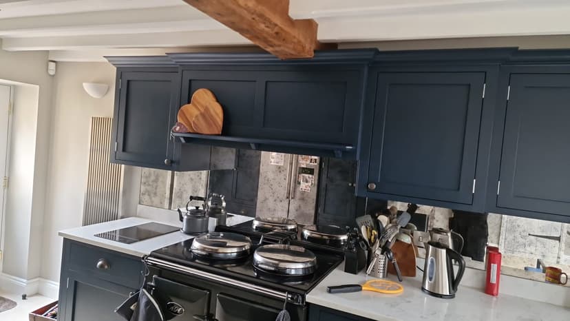 Dark kitchen cabinetry, range cooker and exposed beam